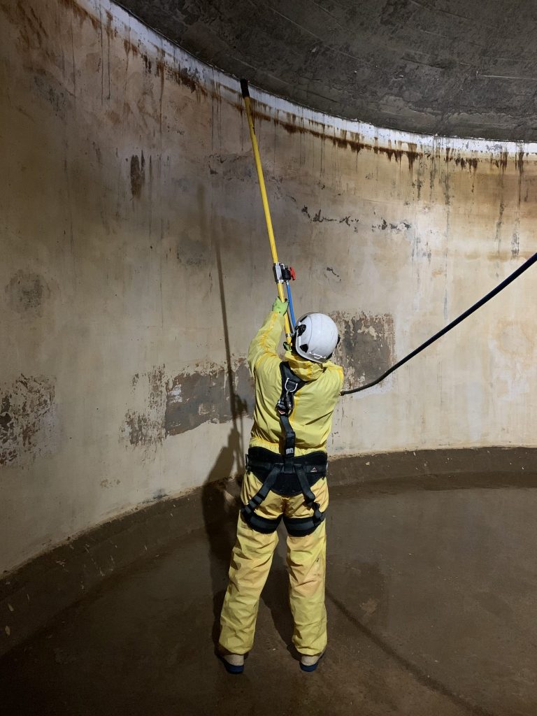 Employé de la société Hp2O en tenue de protection adaptée. Intervient pour une prestation de nettoyage et de désinfection d'un ouvrage d'eau potable.